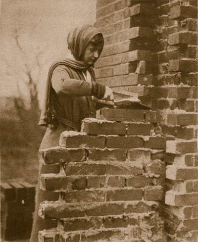 Women work force laying a brick wall by English Photographer